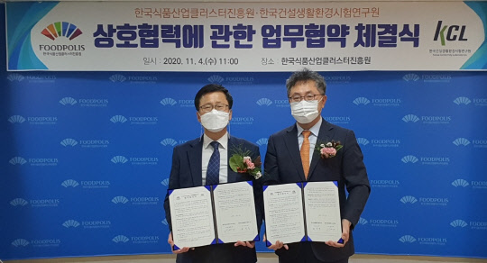 윤갑석 한국건설생활환경시험연구원(KCL) 원장(오른쪽)과 윤태진 한국식품산업클러스터진흥원 이사장이 4일 전라북도 익산 식품산업클러스터진흥원 사옥에서 업무협약을 체결한 뒤 협약서를 함께 들어보이고 있다.  <한국건설생활환경시험연구원 제공>
